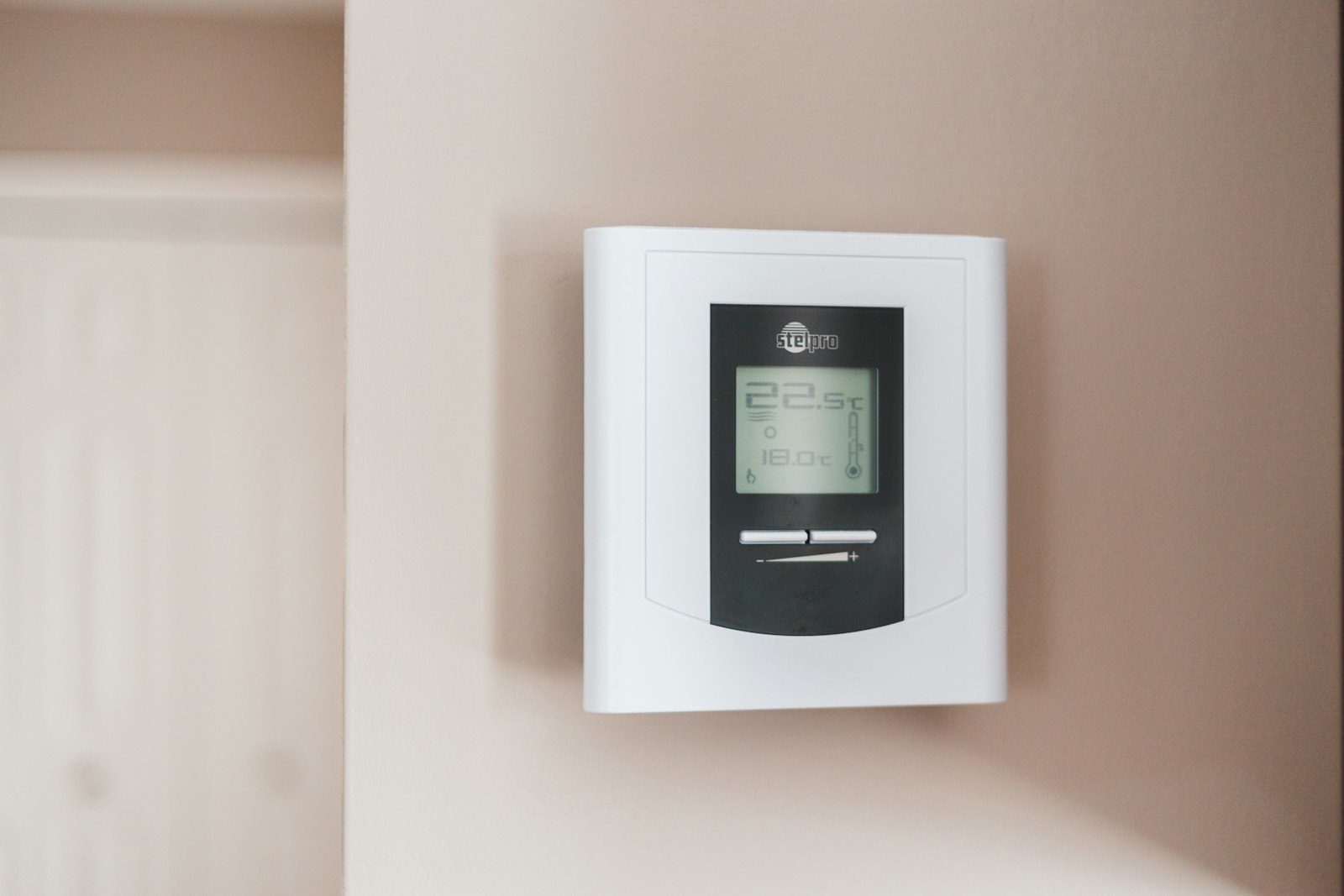 Digital heating thermostat on a wall